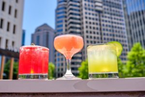 Cocktails in front of an iconic view of Midtown Atlanta from Virtue Rooftop bar at 5Church