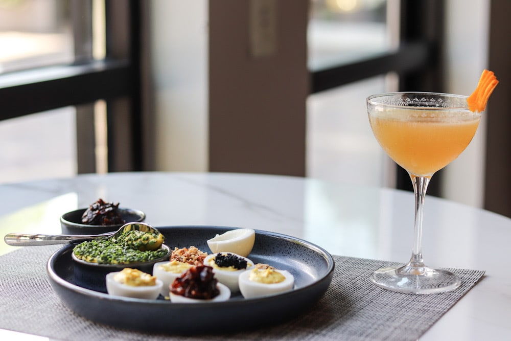 A plate of eggs stuffed with sushi and a cocktail on display at One Flew South.