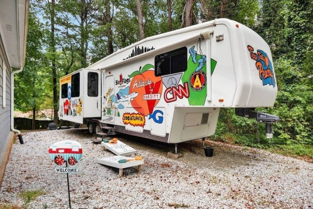 RV turned tiny house, gleaming with Peach State Pride on their muraled exterior