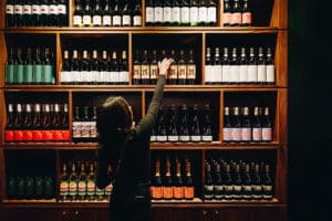 Woman choosing a wine from Postino West Midtowns wine collection