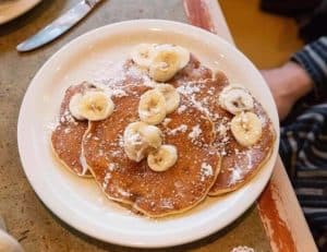 Pancakes topped with bananas and sugared powder at The Original Pancake House