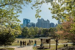 People at Piedmont Park with a view of Midtown Atlanta in between the trees
