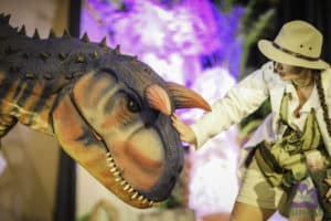 A woman pets a dinosaur puppet