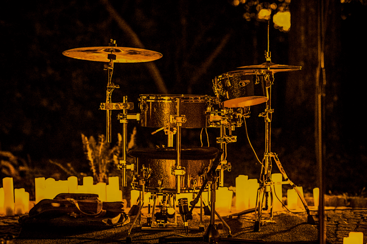 A drumset with candles behind it.