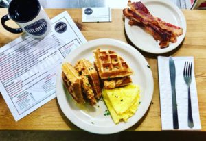 Full spread at the Atlanta Breakfast Club, including their chicken and waffles, served with a side of eggs and bacon