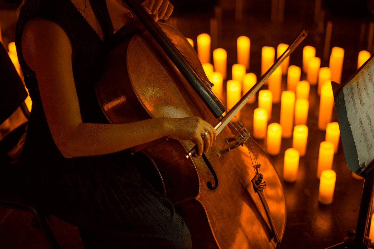 Musician playing instrument by candlelight