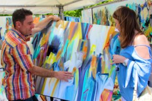 Attendee purchasing art from an artist at Atlanta's Roswell Spring Arts Festival 